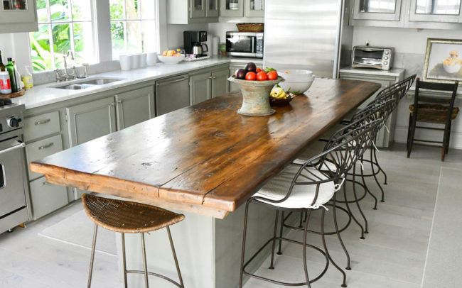 A kitchen island countertop with chairs and decor